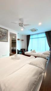 a bedroom with three beds and a large window at LAVANYA Private Pool Villa Residence 2 Floors @ Pantai Cenang. in Pantai Cenang