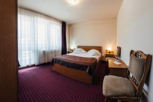 a hotel room with a bed and a chair at Casa Rubin in Gura Humorului +52 photos