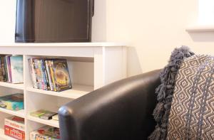 una silla de cuero negro sentada frente a una TV en Abingdon - Private Flat with Garden & Parking 06, en Abingdon
