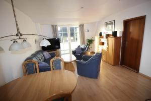 - un salon avec une table en bois et des chaises bleues dans l'établissement Parkside No 8, à Timmendorfer Strand