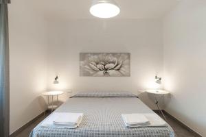 a bedroom with a bed with two lamps and a painting on the wall at Silvy House in Terracina