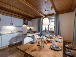 kuchnia i jadalnia z drewnianym stołem i krzesłami w obiekcie Chalet Achenberg w mieście Brixen im Thale