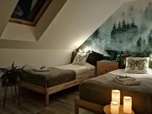 a bedroom with two beds and a painting on the wall at Polne Zacisze in Lgiń