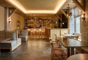 a restaurant with tables and chairs and a bar at Optima Collection Park Hotel Ivano-Frankivsk in Ivano-Frankivsk