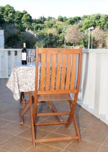 a wooden chair with a table with a bottle of wine at Apartments Briest in Dubrovnik