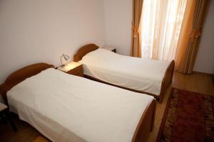 two twin beds in a room with a window at Apartments Briest in Dubrovnik