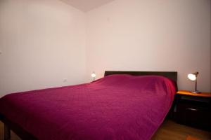 - une chambre avec un lit violet et 2 tables de chevet dans l'établissement Apartments Briest, à Dubrovnik