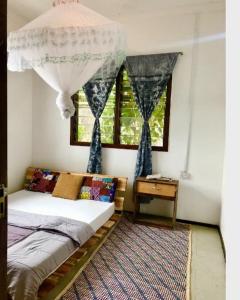 ein Schlafzimmer mit einem Bett mit einem Kronleuchter und einem Fenster in der Unterkunft Mambo & Jambo House in Mwanza