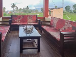 a living room with couches and a coffee table at Saung Aligo Syariah RedPartner in Cipondok