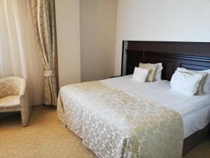 a hotel room with a bed and a chair at Hotel ALPIN - apartament 704 in Poiana Brasov