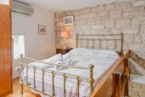 a bed in a room with a stone wall at The Stone House in Egina