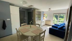 a living room with a table and a blue couch at MAGNIFIQUE Location au bout de la route in Saint-Hilaire-les-Courbes +29 photos