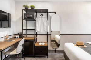 a hotel room with a bed and a desk and a room at The New Port Hotel TLV in Tel Aviv