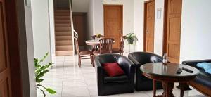 普禾加多的住宿－Guest House Pinarak 2 Syariah near GOR Satria Purwokerto Mitra RedDoorz，客厅配有黑色真皮座椅和桌子