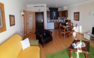 a living room with a yellow couch and a table at Beatrix Apartments in Bük