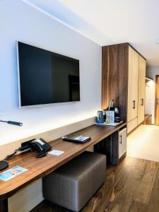 a hotel room with a desk with a large television at Hotel Saratz Pontresina in Pontresina