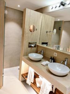 a bathroom with two sinks and a mirror at Hotel Saratz Pontresina in Pontresina