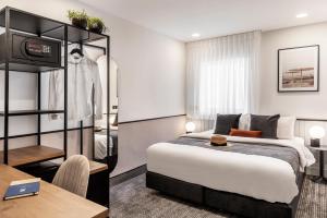 um quarto de hotel com uma cama e uma mesa em The New Port Hotel TLV em Tel Aviv