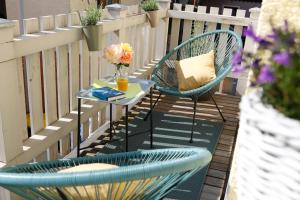 a balcony with two chairs and a table with a vase of flowers at Stilvolle FeWo *Rebland* Balkon-Netflix-Parking in Baden-Baden