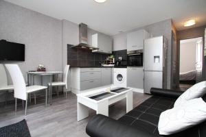 eine Küche und ein Wohnzimmer mit einem Sofa und einem Tisch in der Unterkunft Gite-les-myrtilles in Corcieux