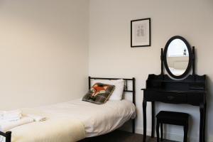 a bedroom with a bed and a mirror and a chair at Abingdon - Private Flat with Garden & Parking 01 in Abingdon