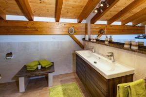 a bathroom with a sink and a wooden ceiling at Ferienwohnungen Sägfeiler in Bischofswiesen