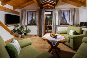 a living room with green chairs and a table at Ferienwohnungen Sägfeiler in Bischofswiesen