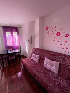 Una sala de estar con un sofá rojo y una mesa. en Apartamento Beatriz, en Cuenca
