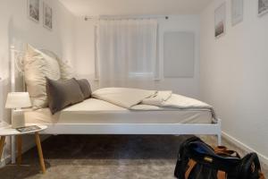 een wit bed in een kamer met een raam bij Stilvolle FeWo *Rebland* Balkon-Netflix-Parking in Baden-Baden
