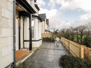 a dog walking down a sidewalk next to a house at Gwynfryn in Trefriw