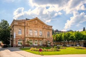 an old building with flowers in front of it at Stilvolle FeWo *Rebland* Balkon-Netflix-Parking in Baden-Baden