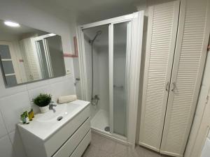 a white bathroom with a shower and a sink at Beach Apartment 8 by SunHousesCanarias in Patalavaca