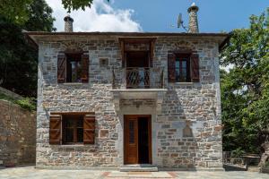 stary kamienny dom z balkonem na górze w obiekcie Helene Eco Luxury Villa w mieście Tsagarada