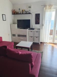 - un salon avec un canapé et une télévision dans l'établissement Modern Two Floors Apartment With A Beautiful View, à Martinšćica