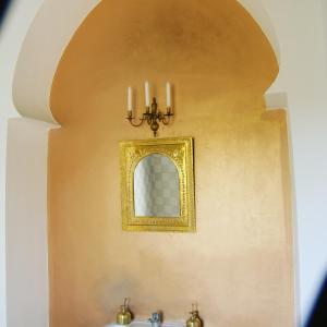 a bathroom with a mirror on a wall with a sink at ferme Walila in Douar Doukkara