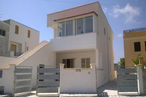 een wit huis met een trap ervoor bij Trilo Torre dell Orso 5 posti Pt33 in Torre dell'Orso