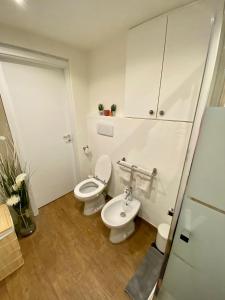 łazienka z 2 toaletami i umywalką w obiekcie casa sol y sombra w mieście Cademario