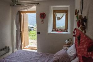 a bedroom with a bed and an open window at CASA BERNARD Zortea VANOI cuore verde del Trentino in Canale San Bovo