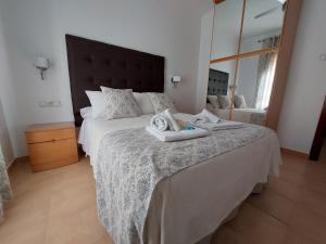a bedroom with a large bed with towels on it at Apartamento Nerja Beach in Nerja