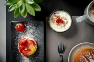 einen Tisch mit zwei Teller mit Lebensmitteln mit Erdbeeren und Haferflocken in der Unterkunft Civico25 Suite Hotel in Gabicce Mare
