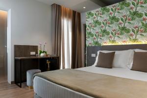 1 dormitorio con 1 cama y escritorio con pared en Civico25 Suite Hotel, en Gabicce Mare