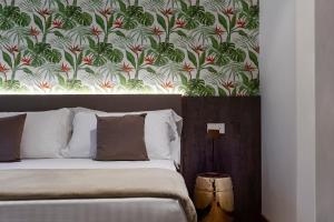 a bedroom with a bed with a floral wallpaper at Civico25 Suite Hotel in Gabicce Mare