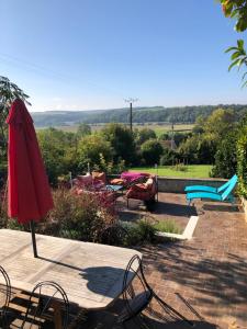 a table with an umbrella and chairs on a patio at Gîte de La Tronchoyse entre vins et nature in Tronchoy