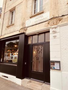 a store front with a black door on a street at Hôtel Le Britannic - centre gare- in Saint Malo