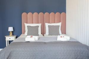 - une chambre avec un grand lit et une tête de lit rose dans l'établissement Alton Aleje Apartment 3, à Varsovie