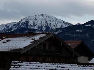 a snow covered mountain in front of a house at Zweite Heimat in Übersee