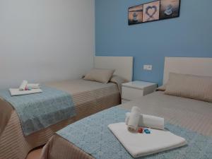 a small room with two beds with towels on them at Apartamento Nerja Beach in Nerja