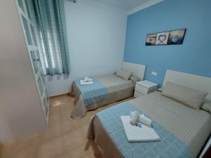 a room with two beds and a table in it at Apartamento Nerja Beach in Nerja