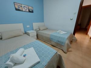 two beds in a room with blue walls at Apartamento Nerja Beach in Nerja