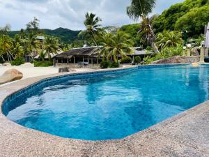 
a beach with a pool and a swimming pool at Villa Chez Batista in Takamaka
